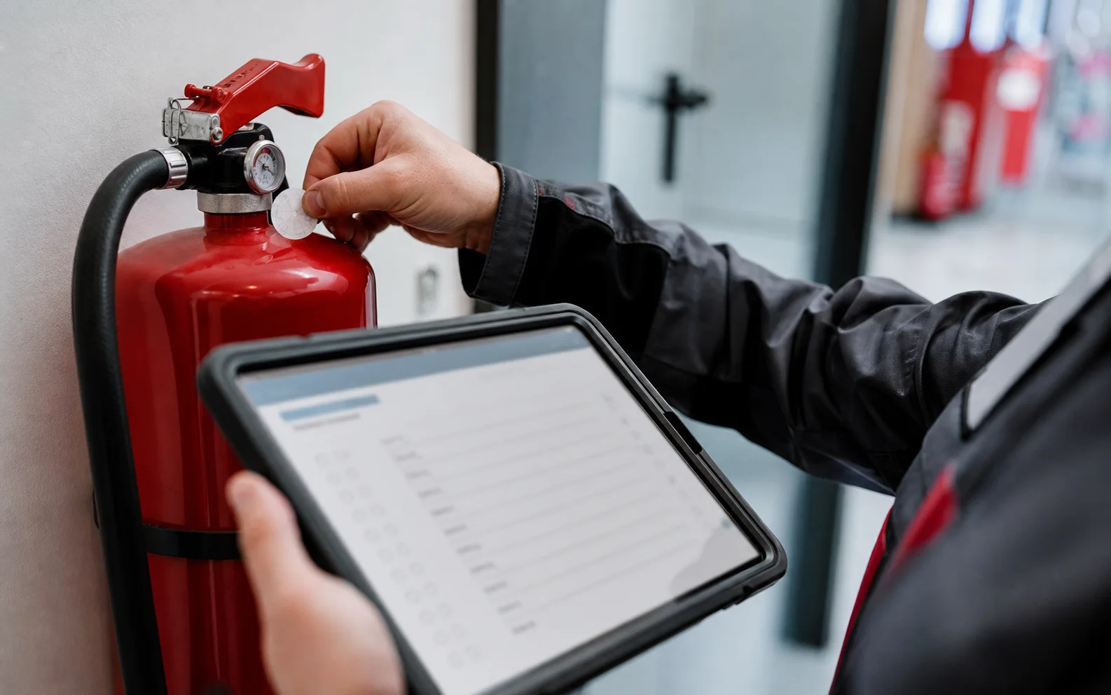 Techniker dokumentiert einen Feuerlöscher mit dem Tablet